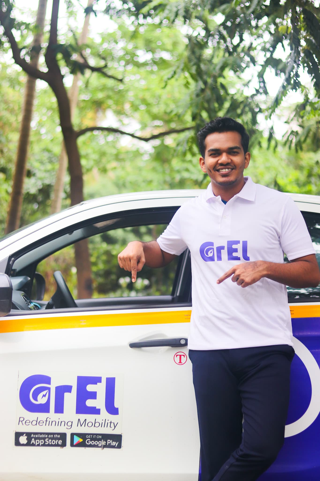 A GrEL team member in a branded polo leaning on a GrEL cab